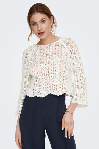 Ecru trui met ronde hals van ONLY, met ajourpatroon en uitlopende mouwen, gecombineerd met een donkere broek.
