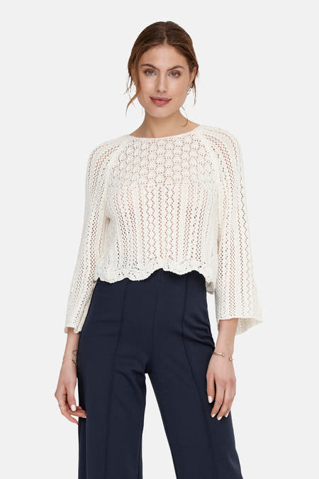 Pull écru ONLY® avec maille ouverte et manches trois quarts, combiné avec un pantalon marine.