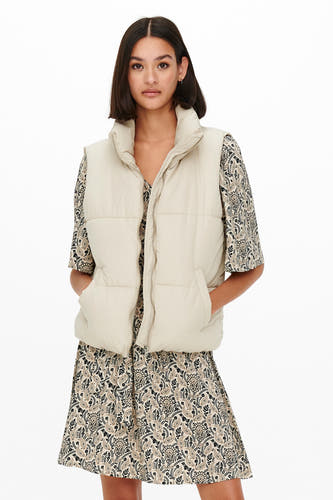 Gilet écru de JDY, associé à une robe imprimée paisley, avec des poches et un col montant.