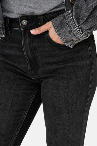 Jean droit noir d'ONLY, avec des mains dans la poche du pantalon et un chemisier gris.