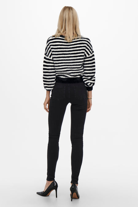 Pull noir avec col rond de la marque ONLY, avec un motif rayé et associé à un jean noir et des talons.