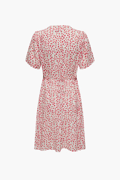 Witte kleedje met korte mouwen van ONLY, met rode bloemenprint en strikceintuur.
