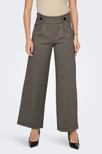 Pantalon gris de JDY, avec un motif pied-de-poule et une large coupe, porté avec des baskets noires.