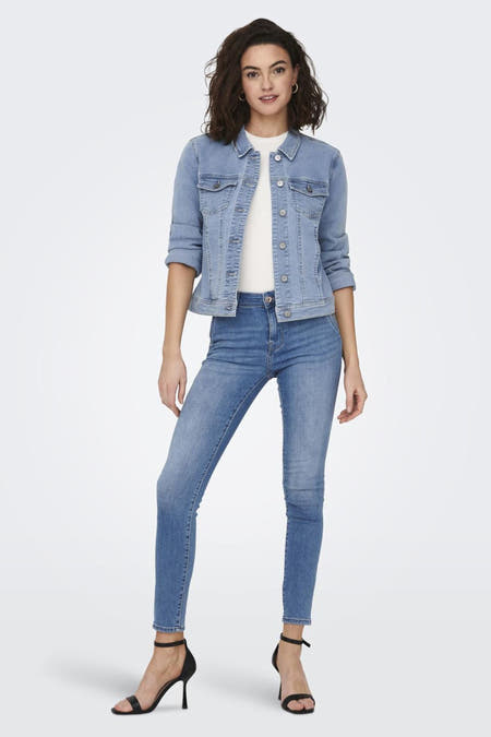 Veste en denim bleu clair courte d'ONLY, avec manches longues, portée avec un pantalon noir et des bottes, vue de dos.