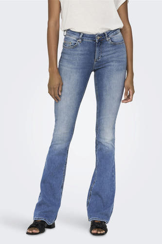 Jean flared bleu clair d'ONLY, avec un lavage clair et porté avec des sandales noires.