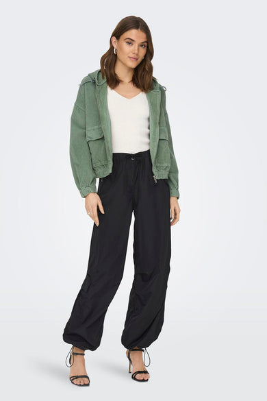 Manteau court vert d'ONLY, avec capuche et porté avec un pantalon noir et des bottes, vue arrière.