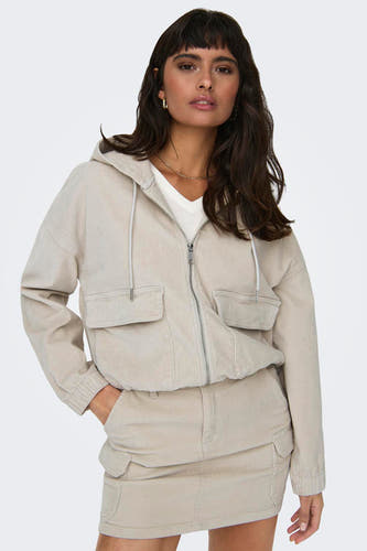 Manteau court écru d'ONLY, avec capuche, fermeture éclair et poches ; associé à une jupe écru.