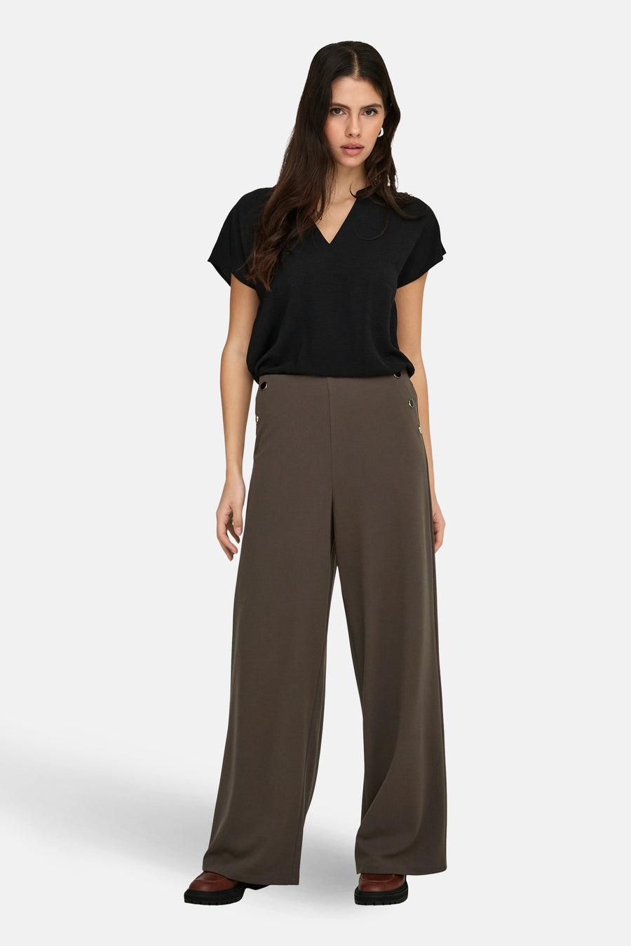 Chemisier noir JDY à manches courtes et col en V, porté avec un pantalon foncé à jambes larges.