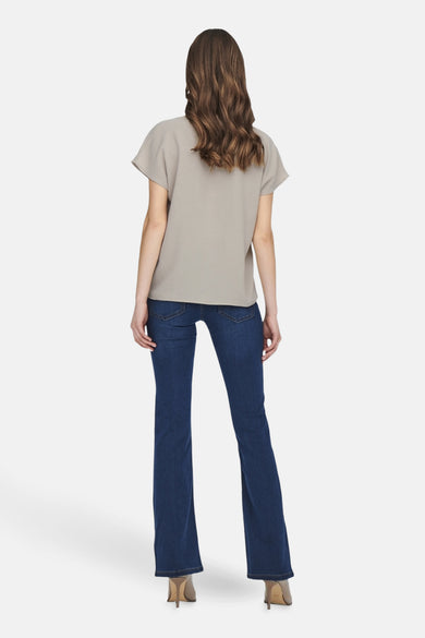 Blouse beige à manches courtes de JDY, dos, associée à des jeans foncés et des talons.