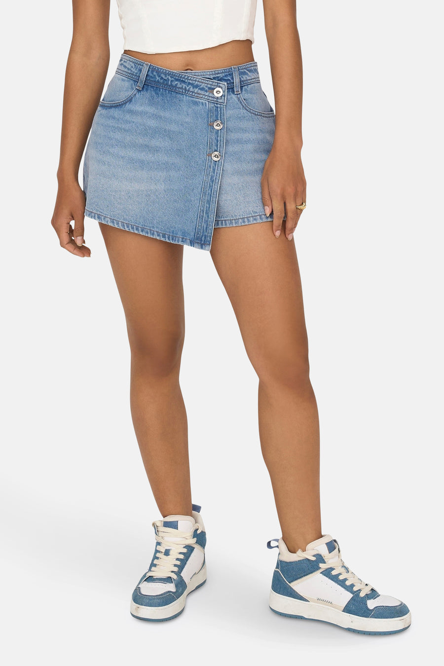 Short light blue denim skirt from ONLY, with a flap detail and silver buttons, paired with white sneakers.