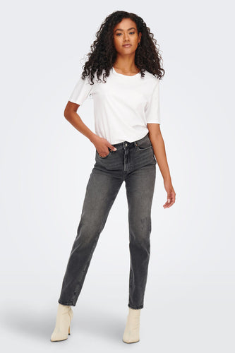 Dos d'une femme en jeans gris, t-shirt blanc et sandales beige sur un fond blanc.