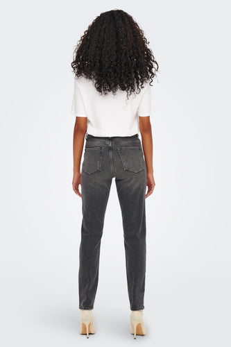 Achterkant van een vrouw in grijze jeans, wit t-shirt en beige hakken op een witte achtergrond.