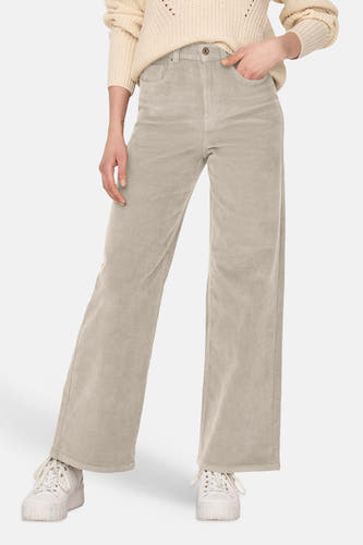 Pantalon couleur velours côtelé oatmeal de ONLY®, coupe large, devant avec poches, texture rayée, modèle portant un pull beige et des baskets blanches