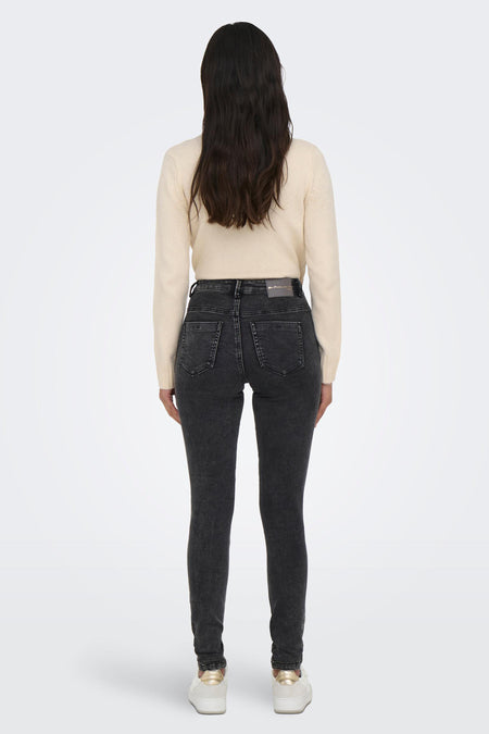 Jean skinny gris foncé de ONLY®, vue arrière, coupe ajustée avec poches, le modèle porte un pull crème et des baskets blanches
