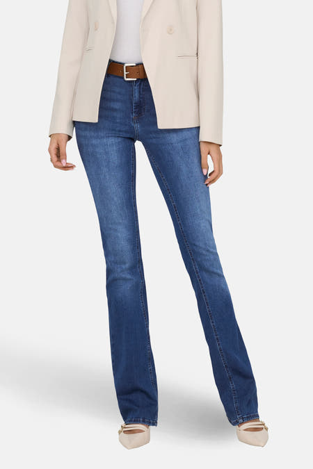 Jean flared bleu foncé d'ONLY avec une ceinture marron et un blazer couleur crème.