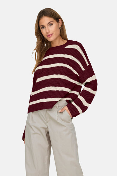 T-shirt rouge à col rond de JDY avec des rayures blanches, porté avec un pantalon beige.