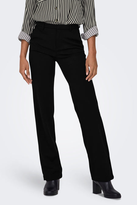 Pantalon noir de ONLY, avec un chemisier rayé et des bottines noires.