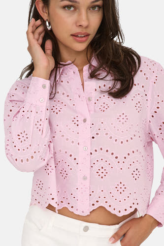 Chemise rose à manches longues de ONLY, avec détails ajourés et portée avec un pantalon blanc.
