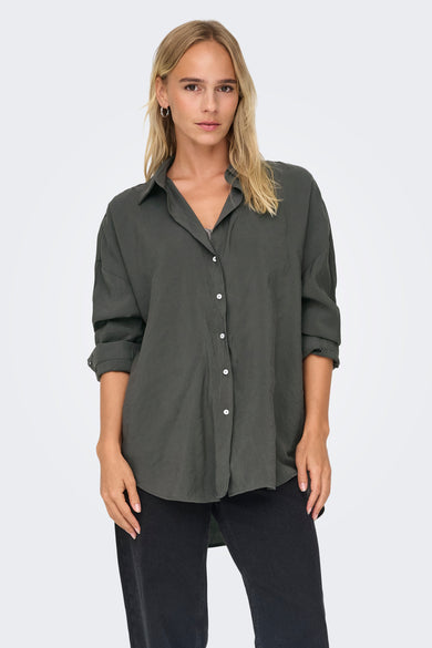 Chemise grise à manches longues de ONLY®, portée avec des jeans noirs et des bottes à talons.