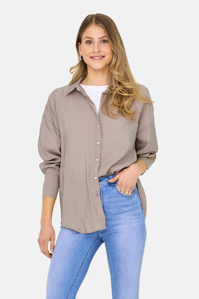 Chemise beige à manches longues de ONLY, avec des plis à l'arrière et une fermeture à boutons.