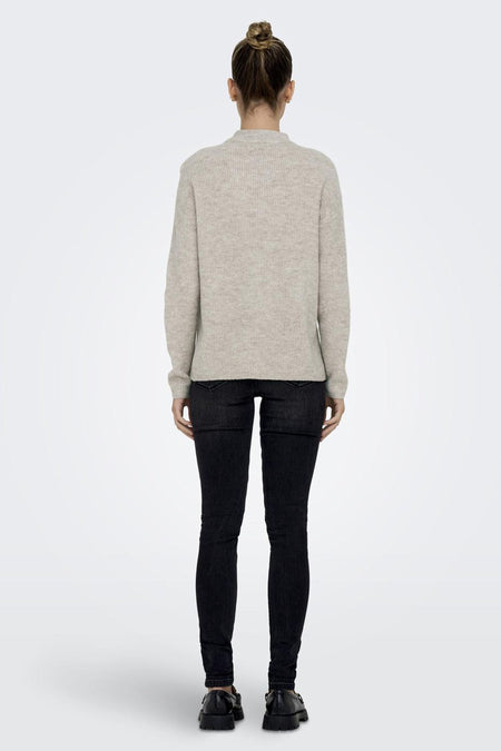 T-shirt écru ONLY®, vu de dos, combiné avec un jean noir et des chaussures noires.