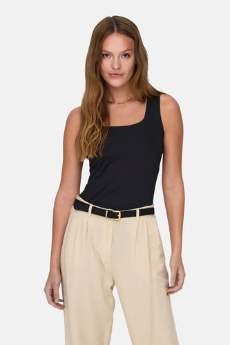 Top noir ONLY, combiné avec une chaîne dorée et un pantalon beige avec ceinture.