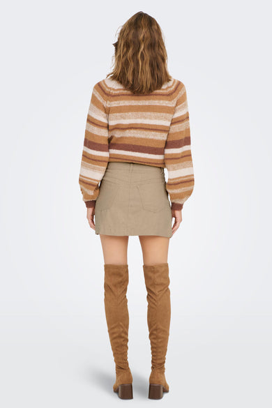 Jupe courte beige de ONLY®, dos avec poches, portée avec un pull rayé et des bottes hautes marron