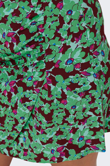 Jupe courte verte d'ONLY, avec un motif floral dans différentes teintes de vert, bordeaux et rose.