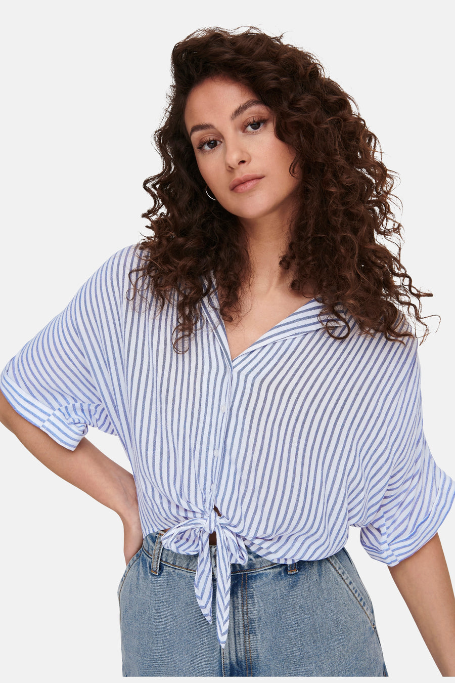 Chemise blanche à manches courtes ONLY®, à rayures bleues et nouée sur le devant, portée sur un jean.