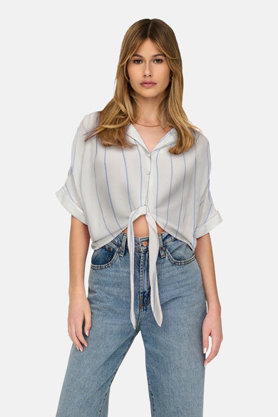 T-shirt blanc à manches courtes de ONLY, avec des rayures verticales bleues, associé à des jeans larges.