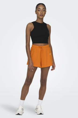 Zwarte top zonder mouwen van ONLY, gedragen met oranje shorts en witte sneakers.