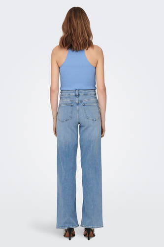 Lichtblauwe, wijde jeans van ONLY, met hoge tailleband en gecombineerd met een blauwe top en zwarte hakken.