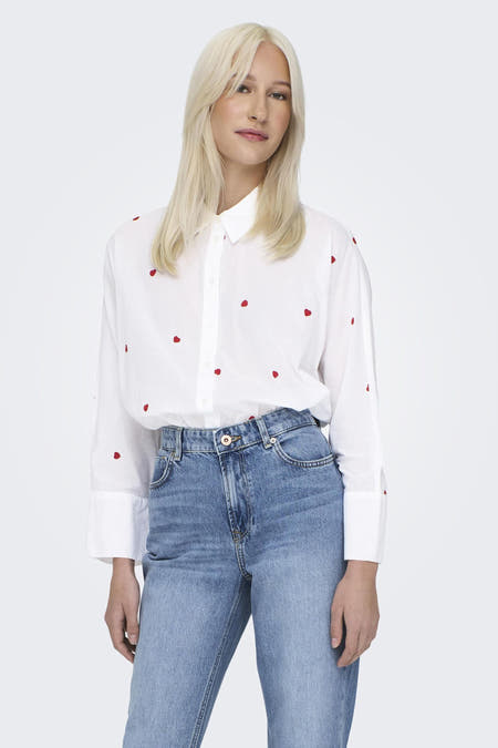 Chemise blanche à manches longues de ONLY, avec broderie citron, portée avec un jean bleu marine.