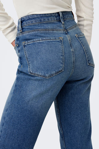 Mid blue denim straight jeans van ONLY, met achterzakken en een witte top.
