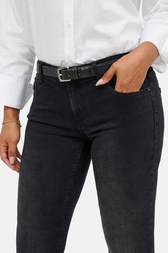 Zwarte flared jeans van ONLY, gedragen met een zwarte riem en een wit overhemd.