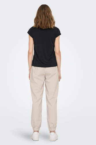 T-shirt noir à manches courtes de ONLY, vu de dos, combiné avec un pantalon beige et des baskets blanches.