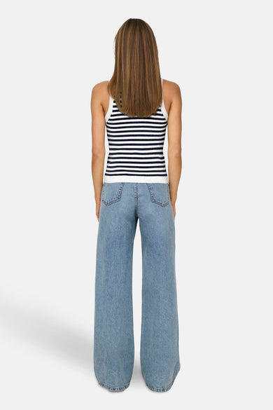 Wit mouwloze top van JDY, met blauwe horizontale strepen, gedragen met wijde jeans.