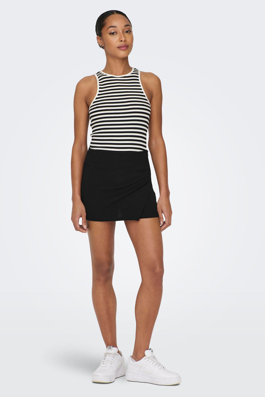 Short JDY noir avec un détail de surpiqûre, associé à une chemise rayée et des baskets blanches.