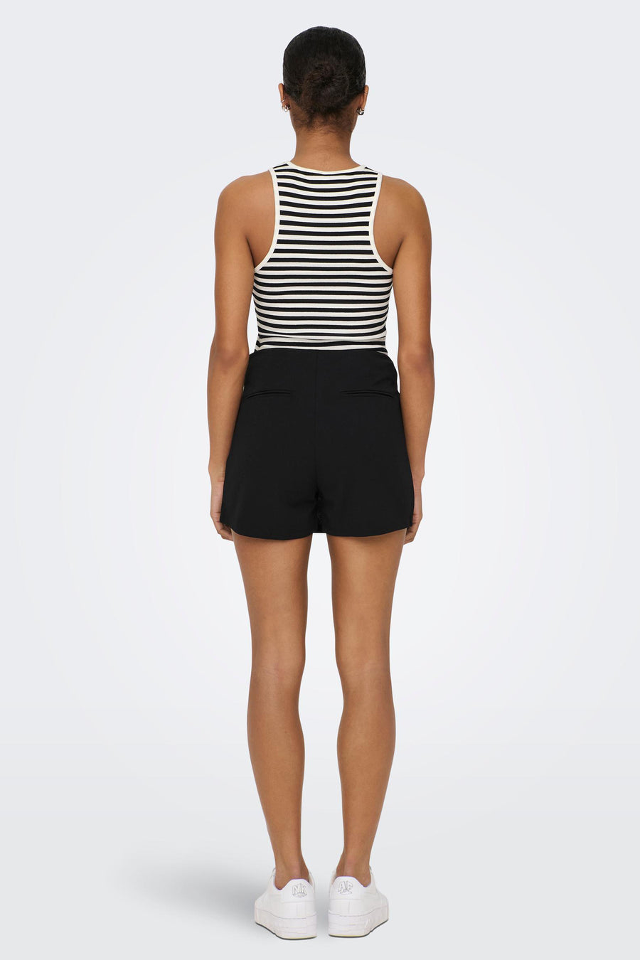 Short JDY Y noir, avec un chemisier rayé et des baskets blanches sur un fond blanc.
