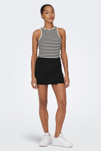 Zwarte skort van JDY, met een overslagdetail, gecombineerd met een gestreepte top en witte sneakers.
