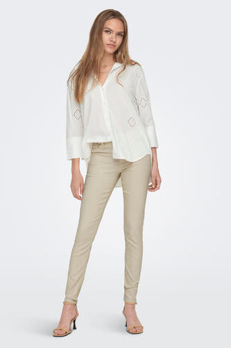 Chemise blanche à longues manches de JDY, avec des détails brodés et associée à un pantalon marron clair et des baskets.