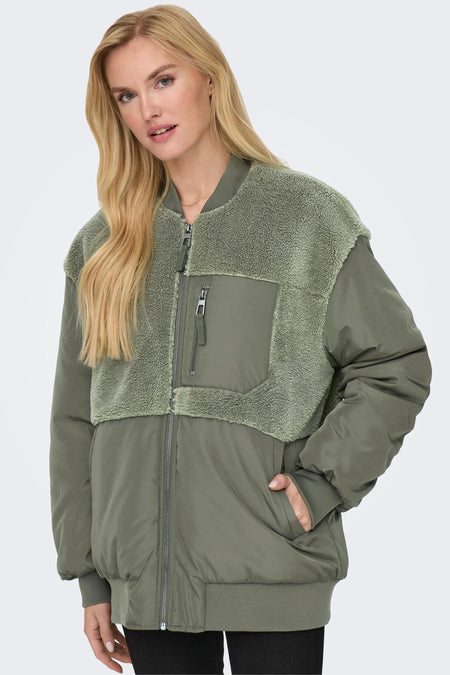 Manteau vert de ONLY, avec des accents teddy et une poche à glissière, porté par un modèle blond.