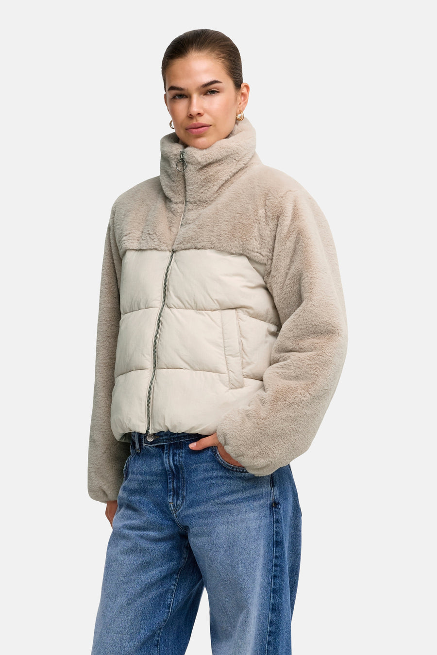Doudoune gris clair avec manches et col en fausse fourrure teddy de la marque ONLY®, dotée d'une fermeture éclair et de poches, portée avec un jean bleu.