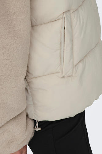 Blouson écru ONLY, avec une douce texture et un détail poche, associé à un pantalon noir.