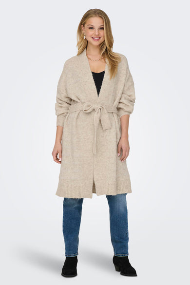 Gilet beige de ONLY, avec ceinture à carreaux, porté sur une chemise noire et des jeans bleus.
