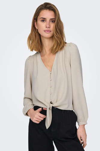 Blouse grise à manches longues d'ONLY, boutonnée sur le devant, portée avec un pantalon noir.