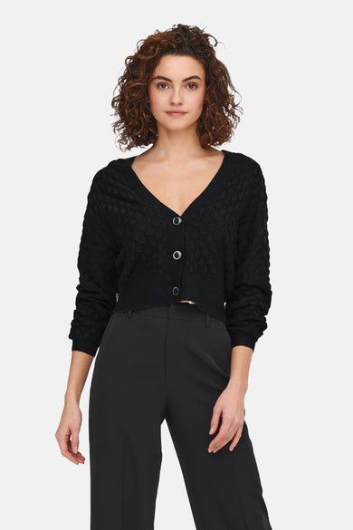 Gilet noir ONLY, avec fermeture à boutons, porté avec un pantalon noir.