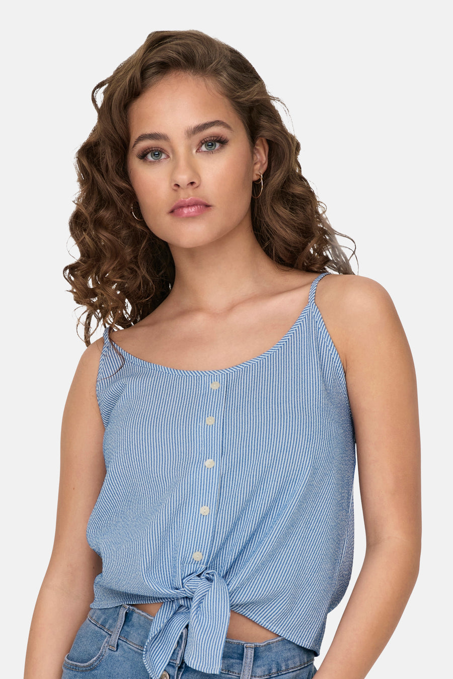 Jonge vrouw met bruin krullend haar, blauw gestreepte top met knopen.