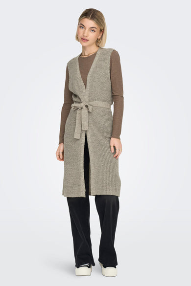 Gilet brun de JDY, avec une texture tricotée, une ceinture coordonnée et un pantalon noir long.