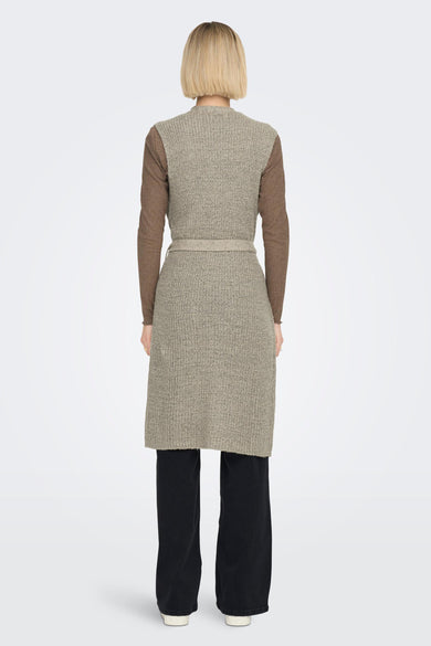 Bruine gilet van JDY, met een gebreide textuur, een bijpassende riem en lange zwarte broek.
